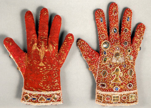 A pair of gloves made of red samite and encrusted with gold embroidery, pearls, precious stones, and small enameled plaques