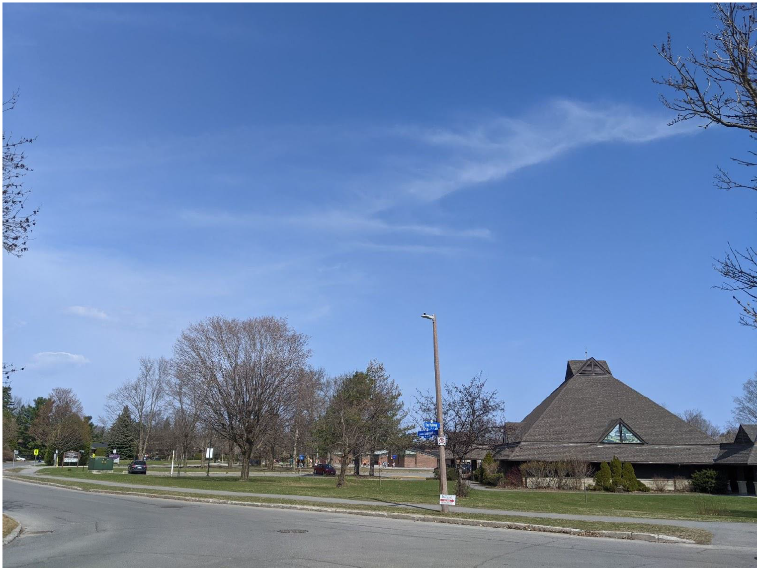 Photograph of the end of The Parkway, showing a road, streelight, place of worhsip, and houses in the distance