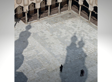 Aerial photograph with shadows of mosques and three human figures