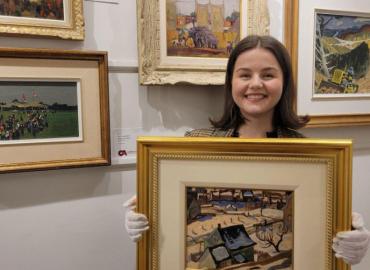 Art History student Emma Kidd holding a painting