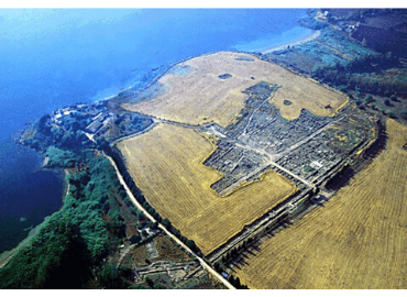 Aerial shor of Megara Hyblaia in Greece. Blue sea, yellow sand, ancient dig site.